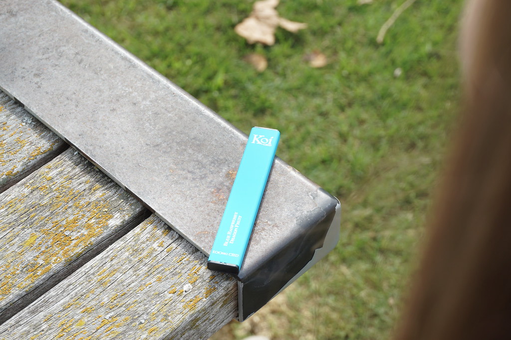Light blue disposable vape resting on a wooden bench